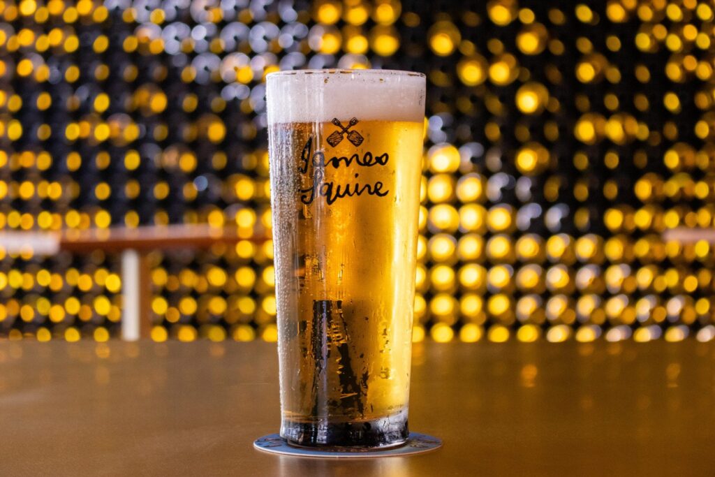 A schooner of James Squire sitting on the bar at The Lucky Squire